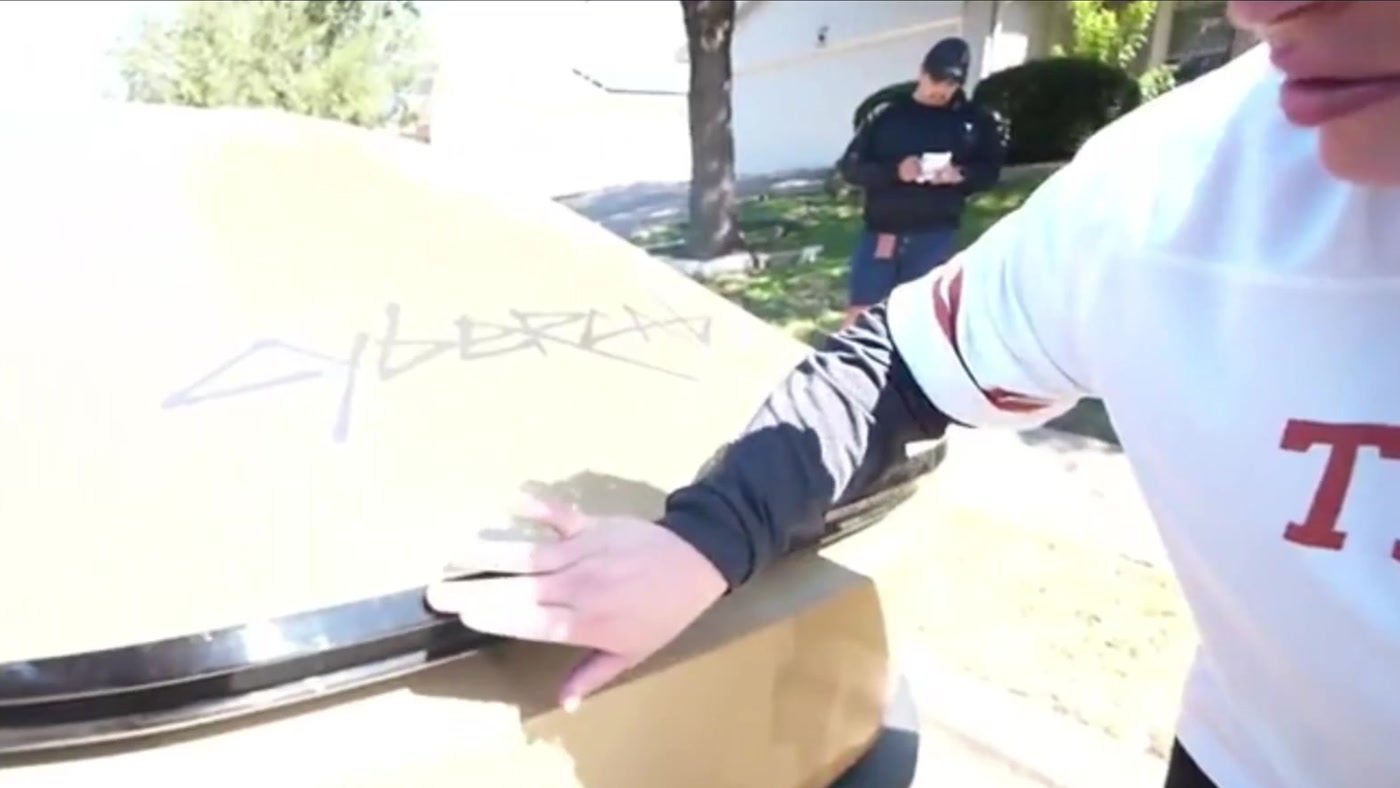 Twitch streamer Sketch checks the back of the gold Tesla Cybercab that was rear-ended during his ride in Austin