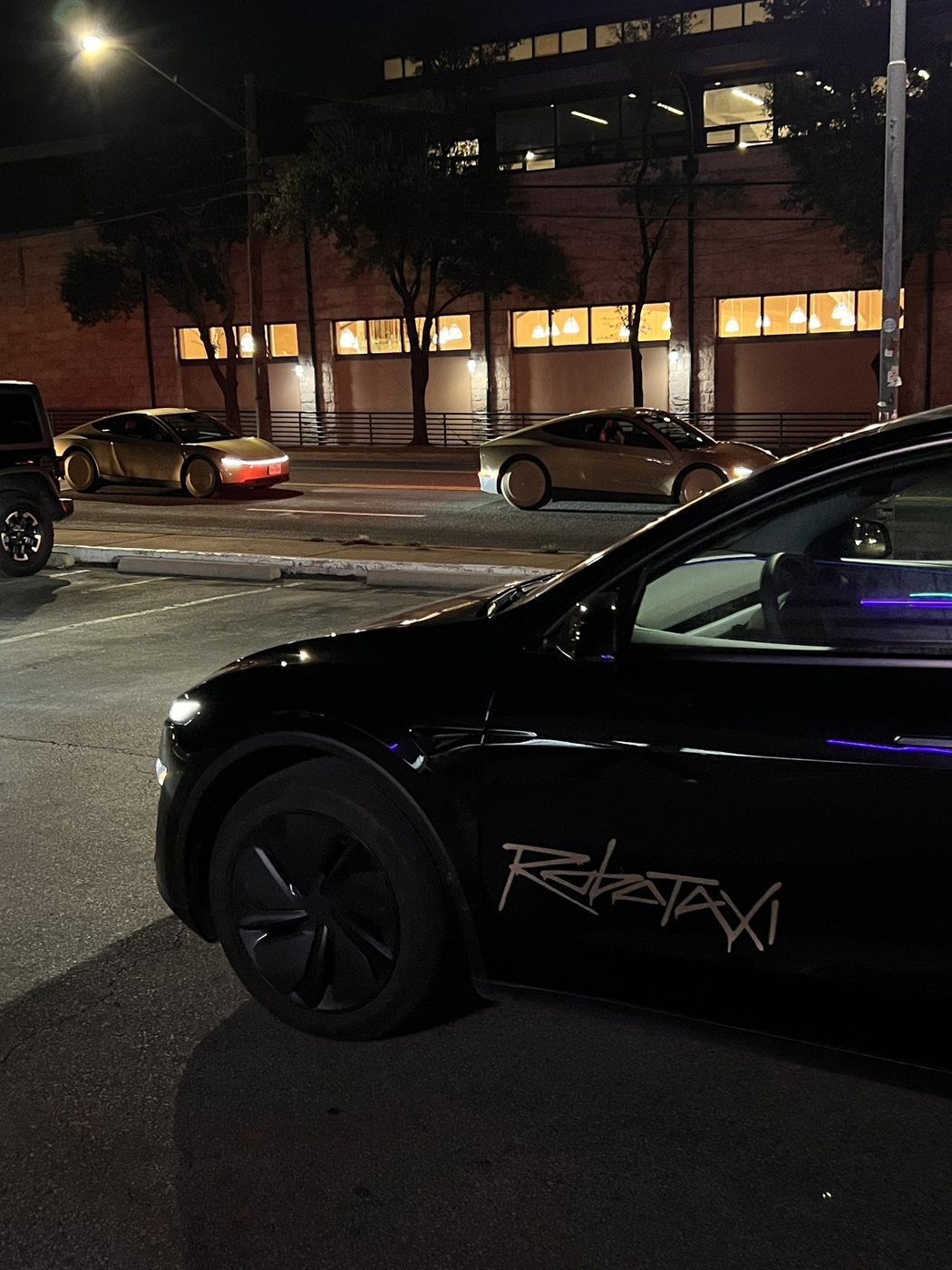 Cybercabs in the background of a Tuesday night Robotaxi trip in Austin. Photo via @gailalfaratx / X