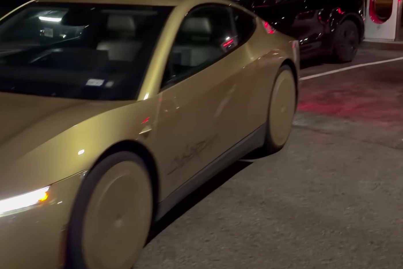 The driverless Cybercab rolls through the Supercharger lot with nobody aboard. Frame from video via @WorldlyReviewer / X
