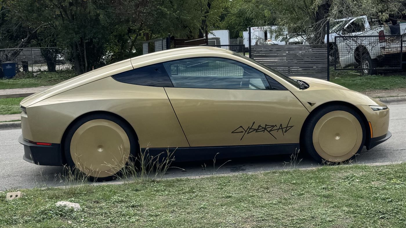 A gold Tesla Cybercab parked at the kerb beside a grass verge (file photo)