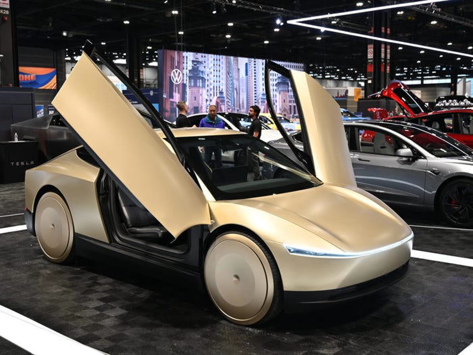 Cybercab on an auto-show stand with both butterfly doors raised