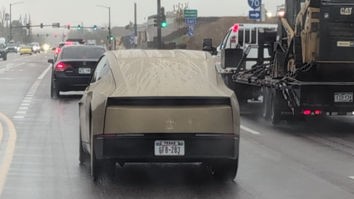 The same Cybercab from behind in Wheat Ridge, with its rear light bar, a Texas plate and an Interstate 70 sign ahead. Image via @koss5280 / X