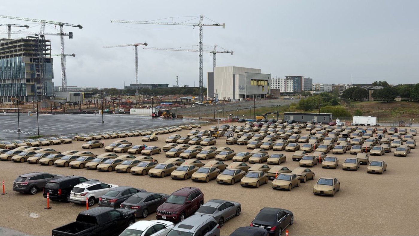 Rows of Tesla Cybercabs parked in a large lot, in a photo an X user said was taken in Dallas