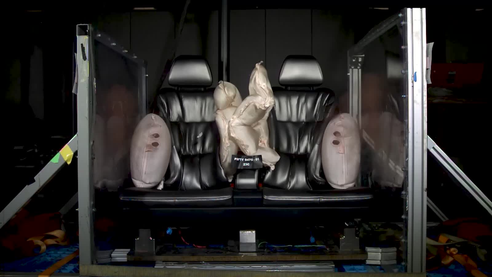A champagne-gold Cybercab on a crash-lab floor meeting a side-impact pole, sensors and fiducials on the body.
