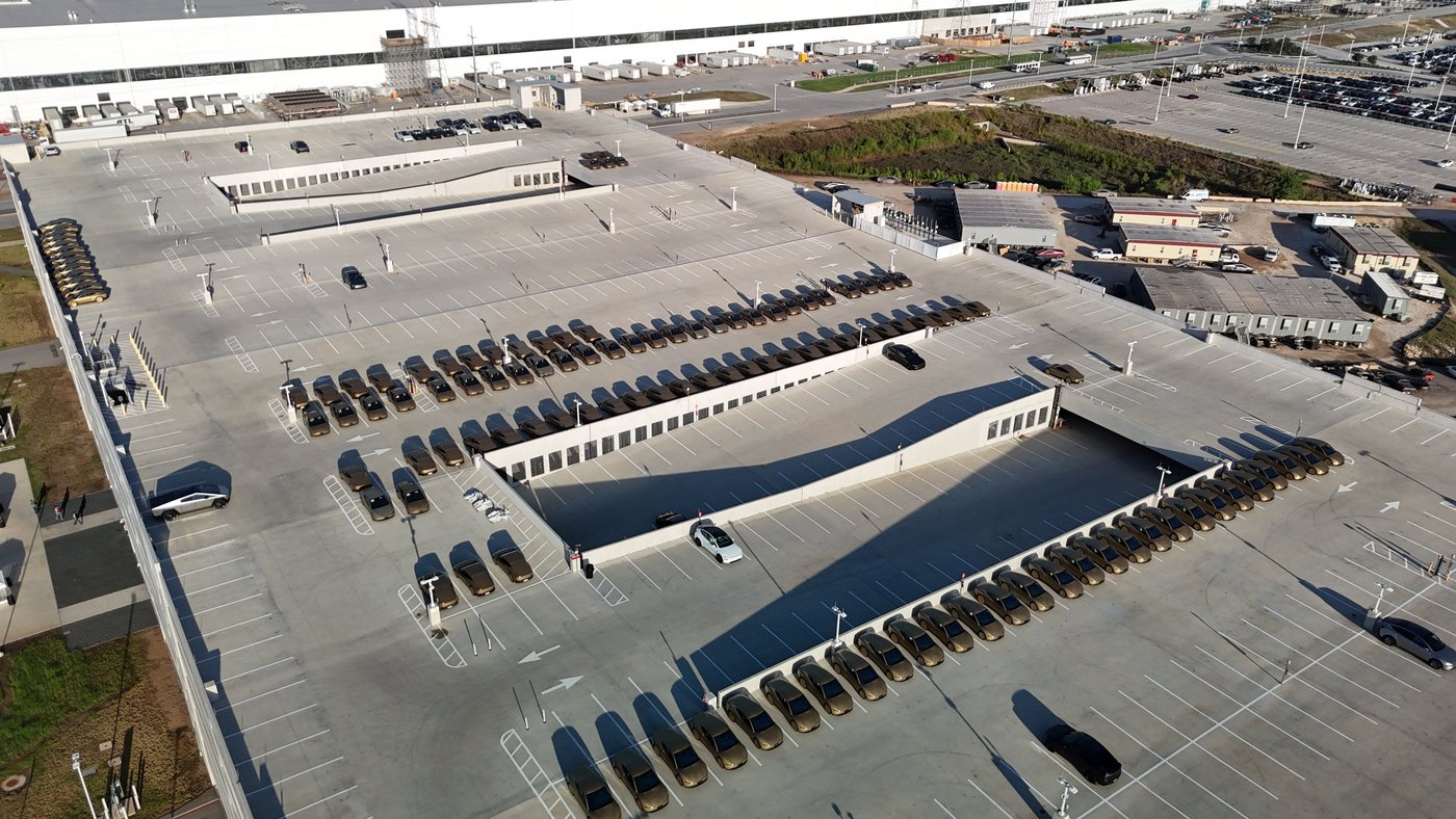 Rows of gold Tesla Cybercabs parked on the roof of the east parking garage at Giga Texas, seen from a drone