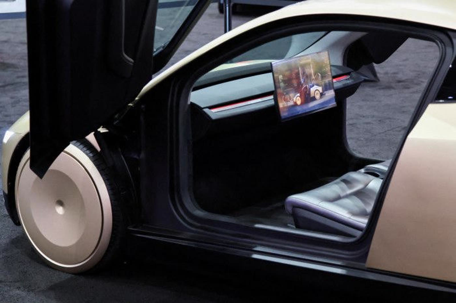 Open Cybercab butterfly door revealing the two-seat cabin and mounted screen