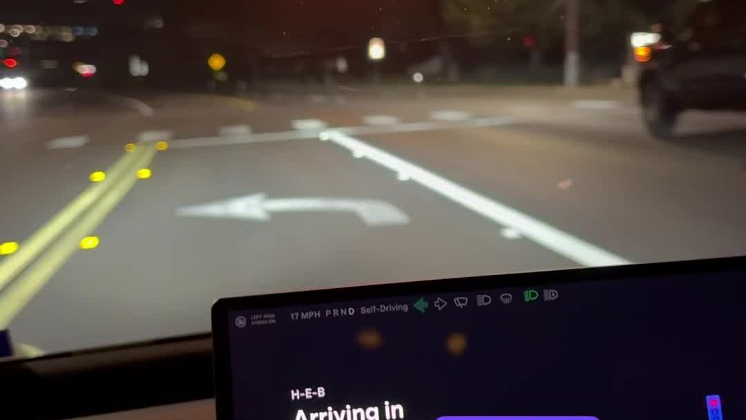 A rider's view from a Tesla Cybercab in Austin after midnight on Sunday, with the cabin screen showing Self-Driving. Frame from video by @WorldlyReviewer / X