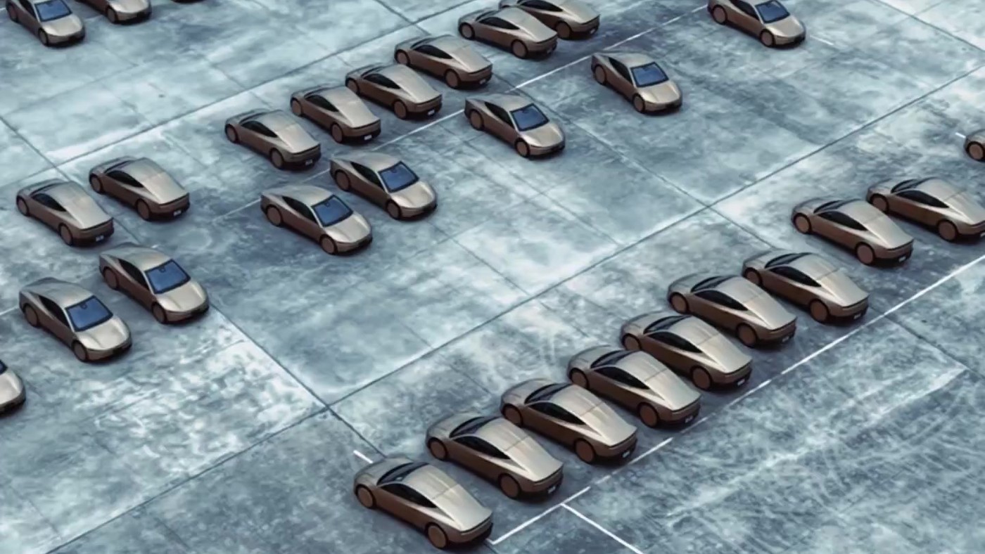 A drone view of rows of gold Tesla Cybercabs parked at a fleet lot in Houston