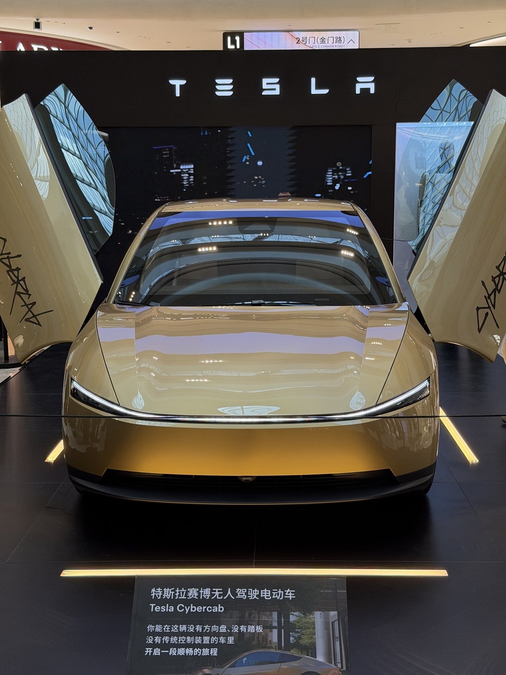 The Cybercab on its Suzhou stage, with a placard describing a car with no steering wheel, no pedals and no traditional controls. Photo via @TeslasRUs / X