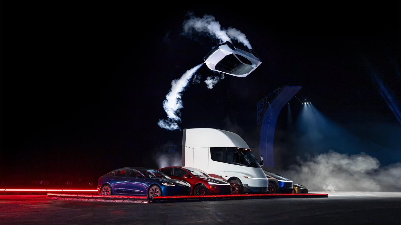 Tesla's new Roadster flipping in midair above a row of Tesla vehicles, including a Semi, at night at SpaceX's test site in McGregor, Texas