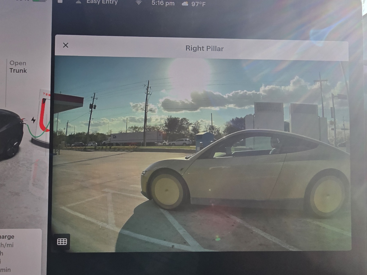 A Cybercab on a Tesla's right pillar camera view at the Westmoreland Supercharger in Dallas. Photo via @durai_ashwin08 / X
