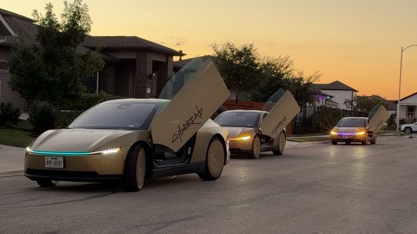 Three gold Tesla Cybercabs with butterfly doors open in a dusk convoy on a residential street in Austin