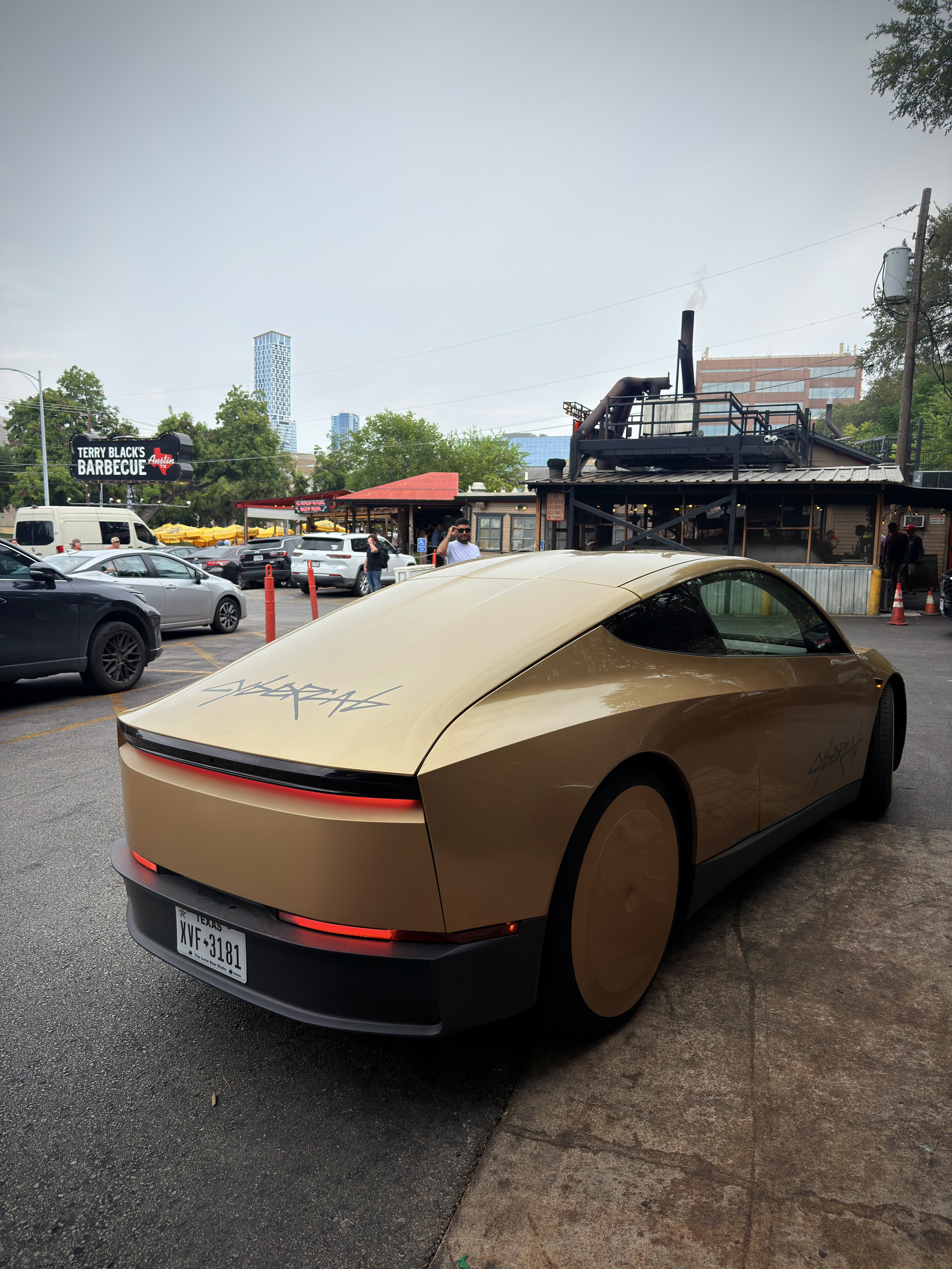 A gold Cybercab parked at Terry Black's Barbecue in Austin after a public Robotaxi ride