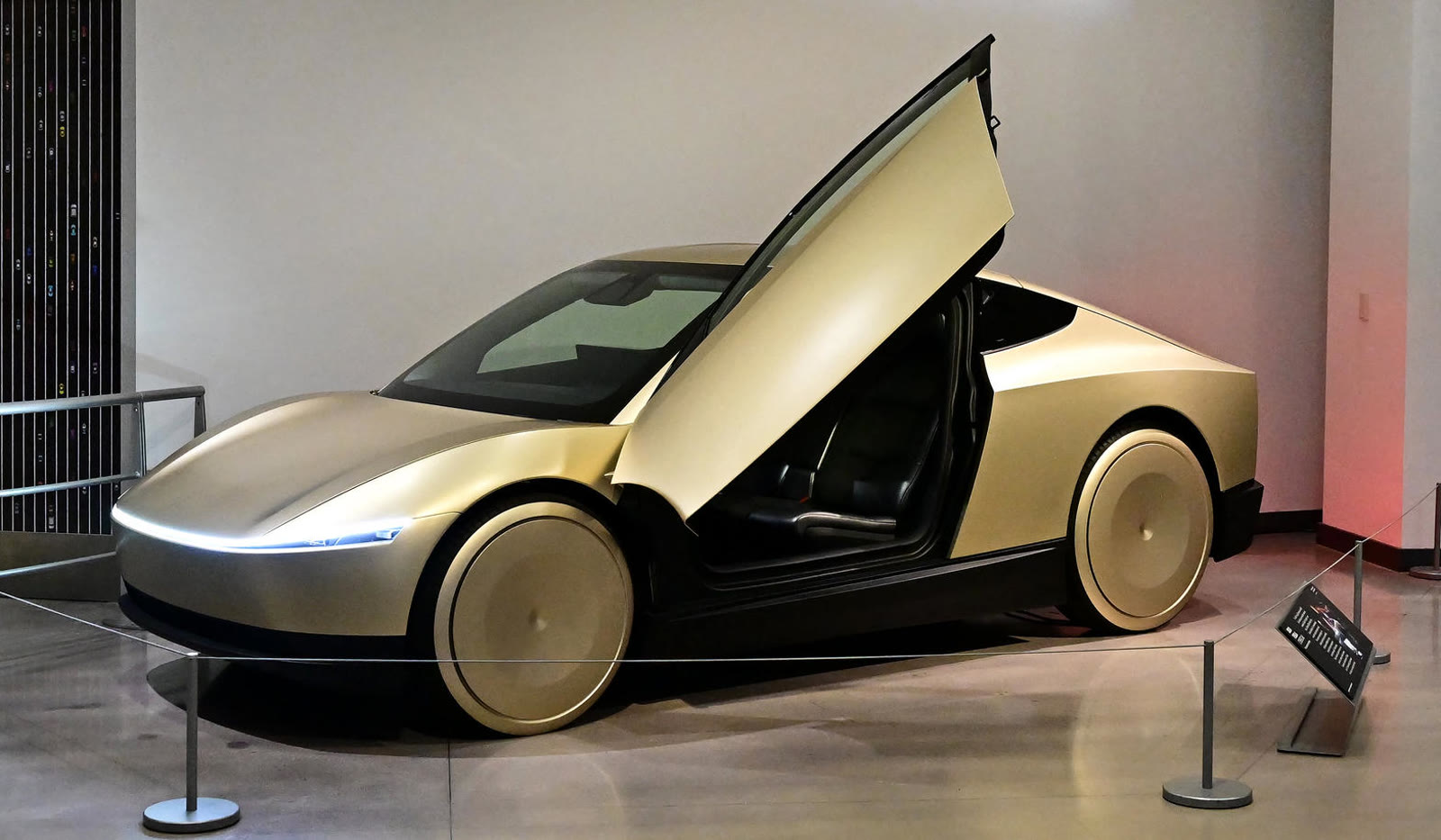 Cybercab on display with a butterfly door raised in a gallery setting