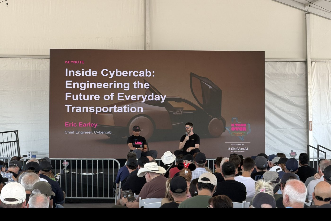 Cybercab chief engineer Eric Earley on stage under an Inside Cybercab keynote screen at X Takeover, Giga Texas