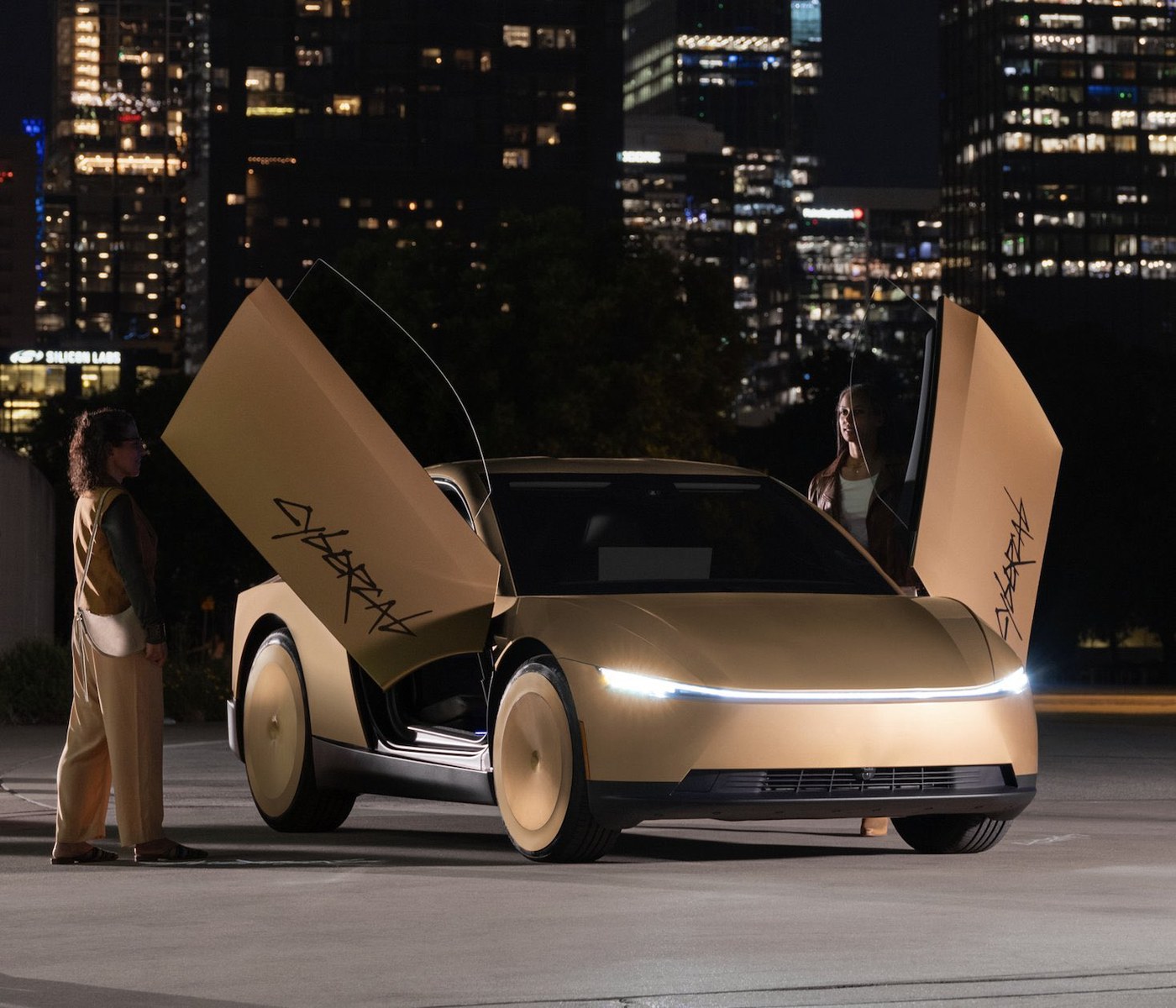 A gold Tesla Cybercab with both doors open at night in Austin, with the city skyline behind it