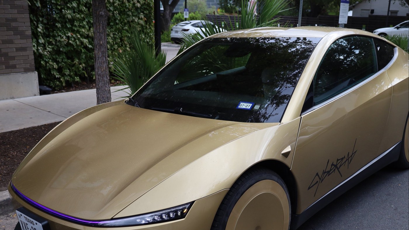 A gold Tesla Cybercab with Texas plates parked at a kerb on an Austin street